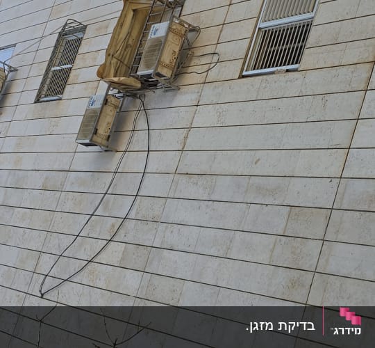 יחידות מיזוג אוויר מותקנות על קיר חיצוני של בניין.